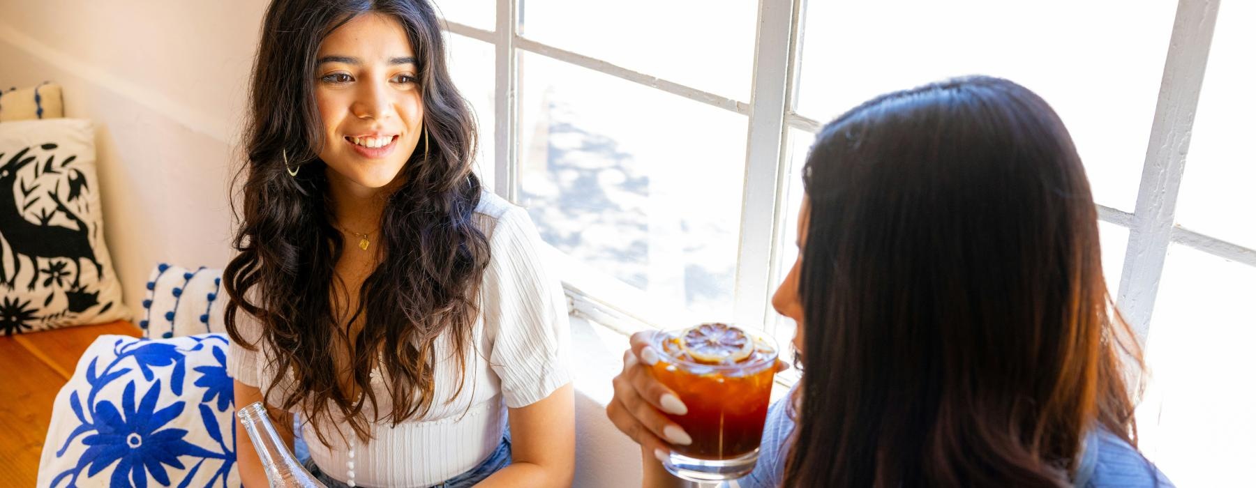a couple of women sitting down with drinks
