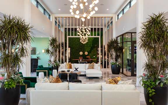 a living room filled with furniture and plants at Esplanade District Apartments, Little Rock, AR,72114