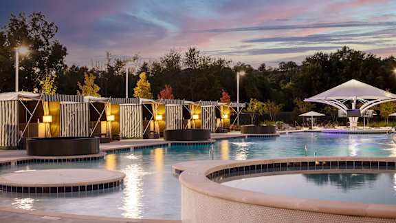a swimming pool at night with a sunset in the background at Esplanade District Apartments, Little Rock, Arkansas