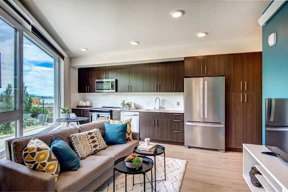 A modern kitchen with a couch and a table.