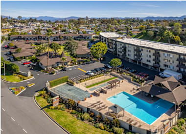 Apartments for Rent in El Cajon CA - Ivanhoe Village - Aerial View of Outdoor Amenities Including the Pool, Basketball Court, and Horse Shoes as Well as the Apartment Building and Parking Lot