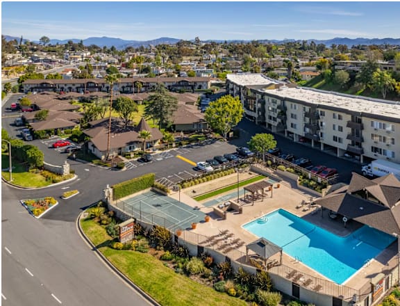 an aerial view of the resort style pool and tennis courts at the club at rolling hills in