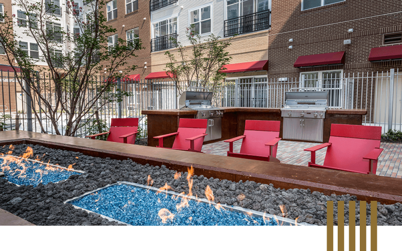a backyard with red chairs and a tree