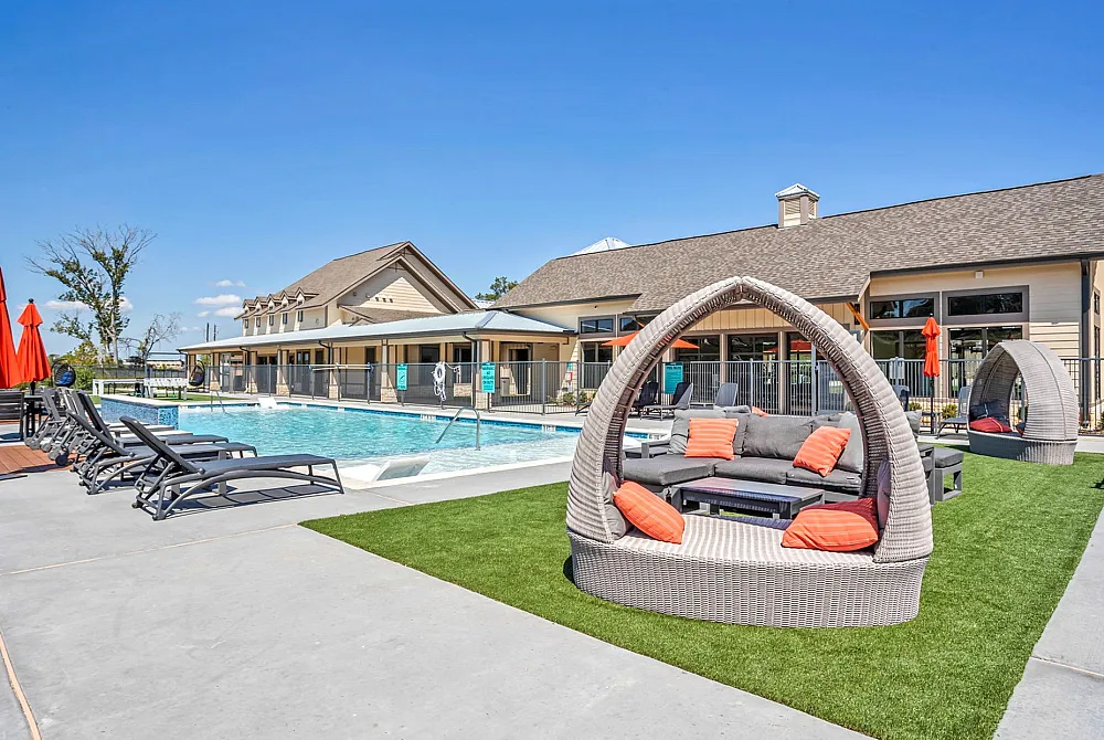 Luxurious outdoor pool area with stylish loungers and cozy seating under vibrant umbrellas, perfect for relaxation and entertainment.