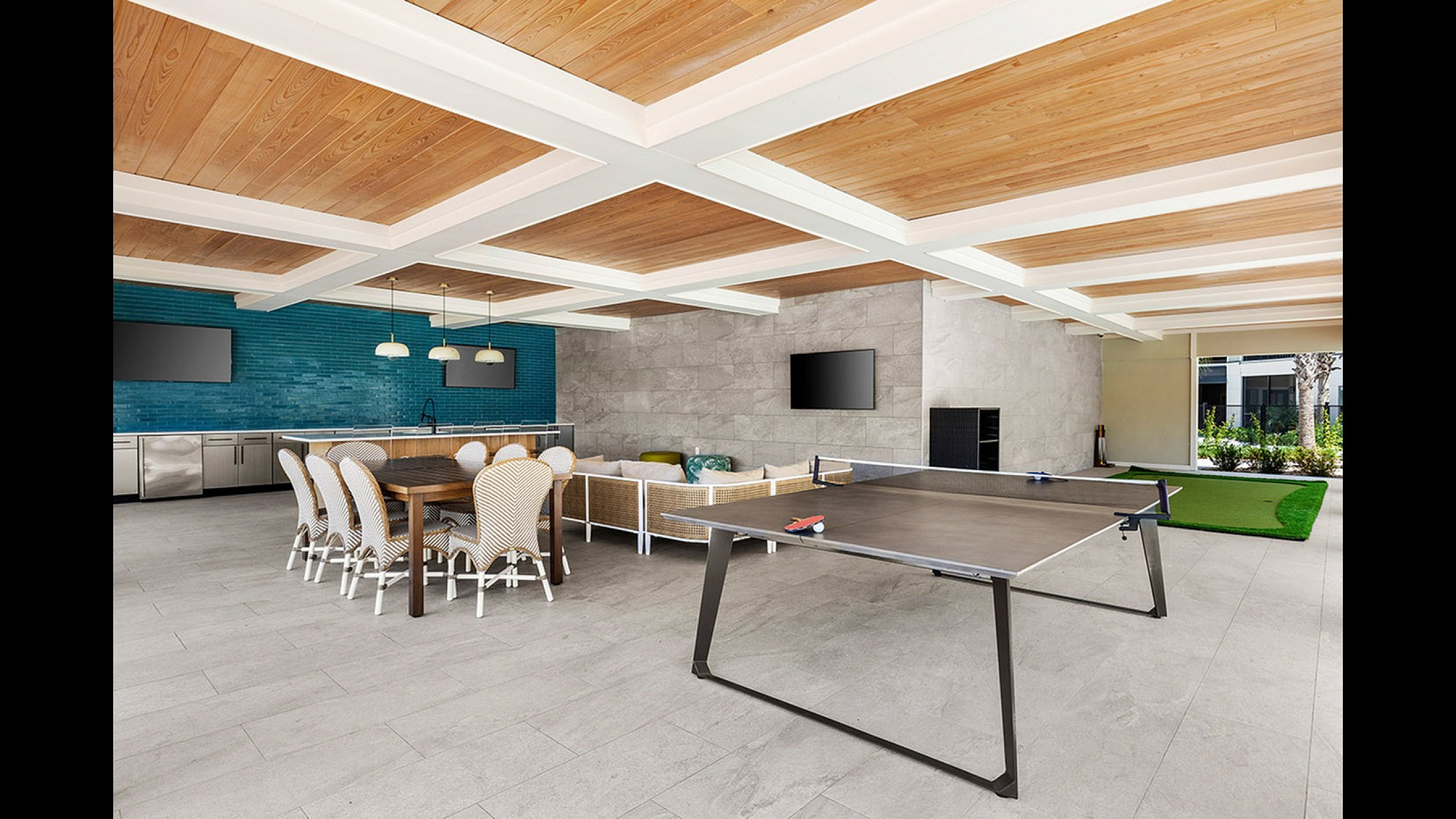 Contemporary recreational room featuring a sleek ping pong table, inviting lounge area, and modern kitchen with elegant dining space.