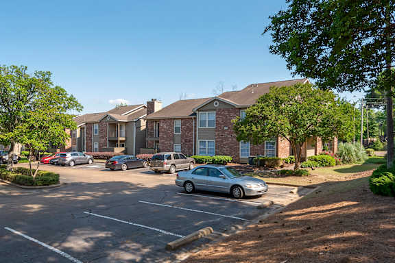 A parking lot with cars and apartment buildings in the background at Pear Orchard, Mississippi, 39157
