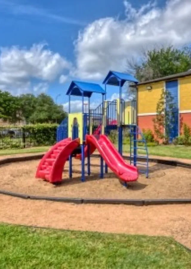 Vibrant playground with colorful slides and climbing structures set against a sunny backdrop, perfect for family-friendly communities.
