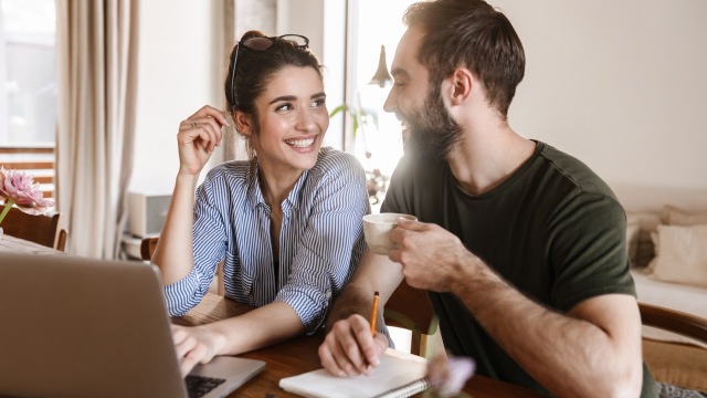 a couple laughing with a computer