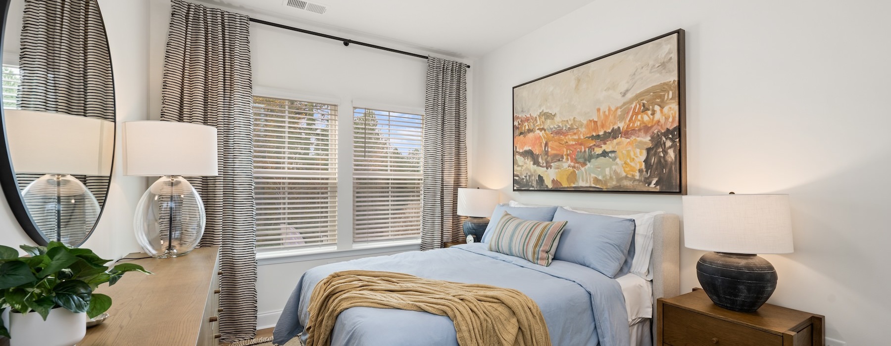 A spacious bedroom with a bed and a dresser at Marglyn Matthews homes in Matthews, NC.