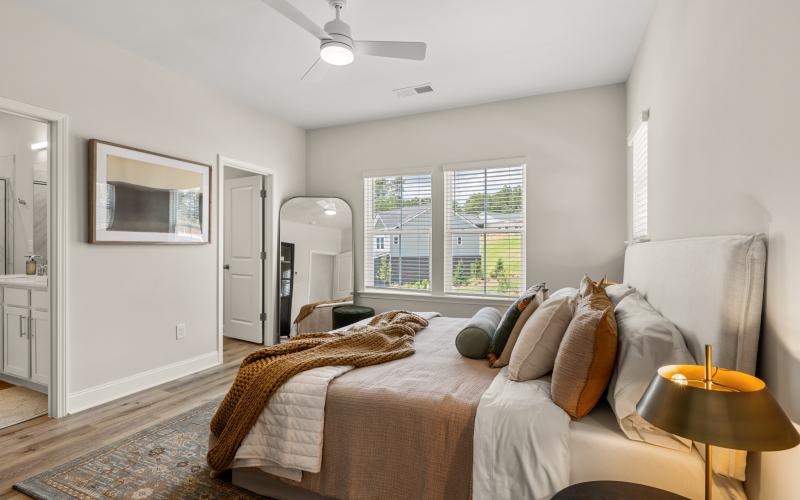 A bedroom with a bed and a fan at Marglyn Matthews homes in Matthews, NC.