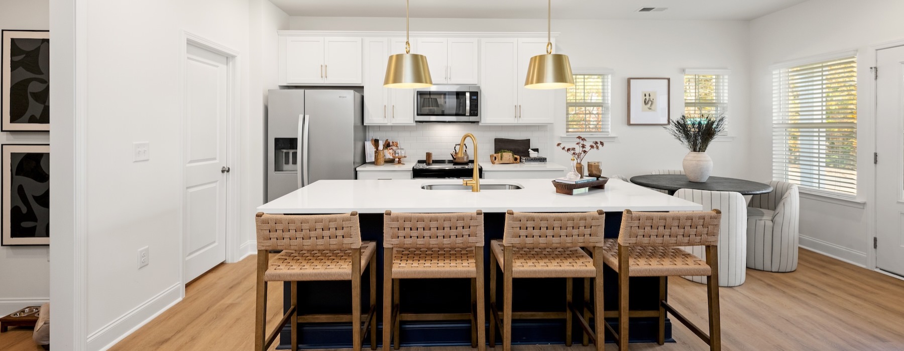 A kitchen with an island and chairs at Marglyn Matthews townhomes in Matthews, NC.