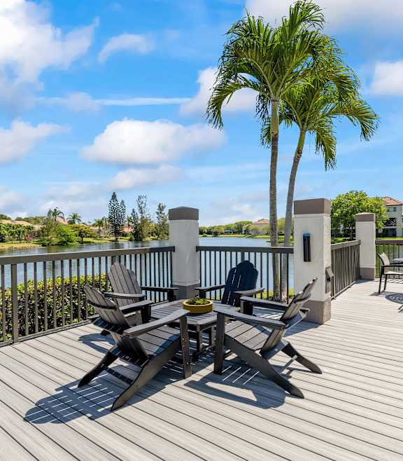 A wooden deck with a table and chairs at Waterview at Coconut Creek, Florida 33073