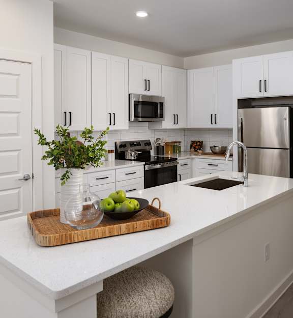 A modern kitchen with white cabinets and a large island.