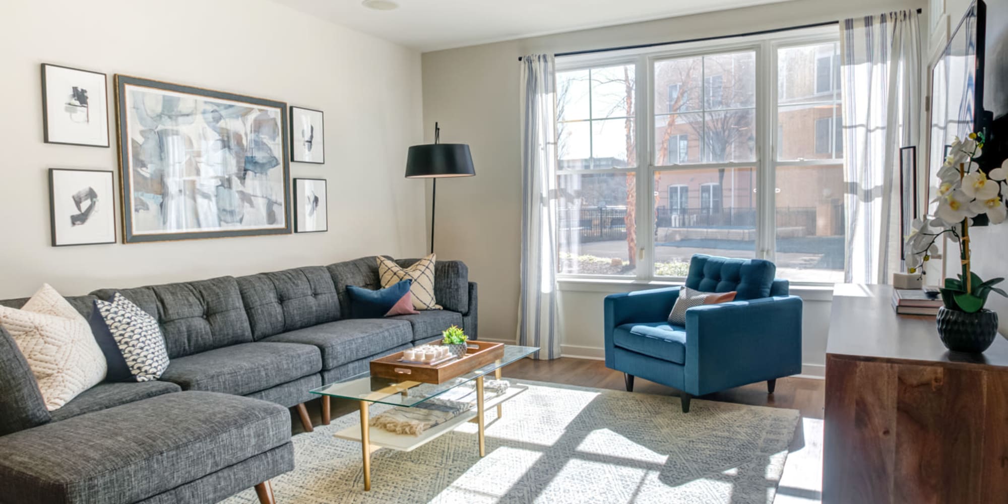 Carpeted Living Room with Glass Center Table at Sofi at Morristown Station in Morristown, New Jersey