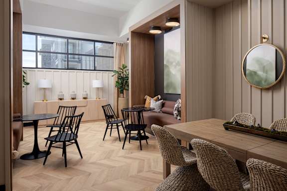 A modern dining room with wooden furniture and a large window.