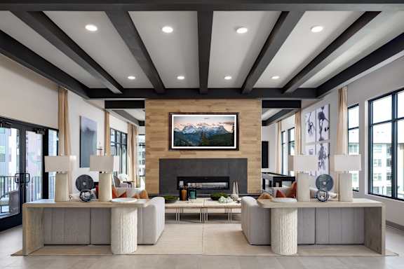 A modern living room with a fireplace and a large painting above it.