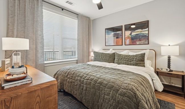 A bedroom with a large bed and a ceiling fan.