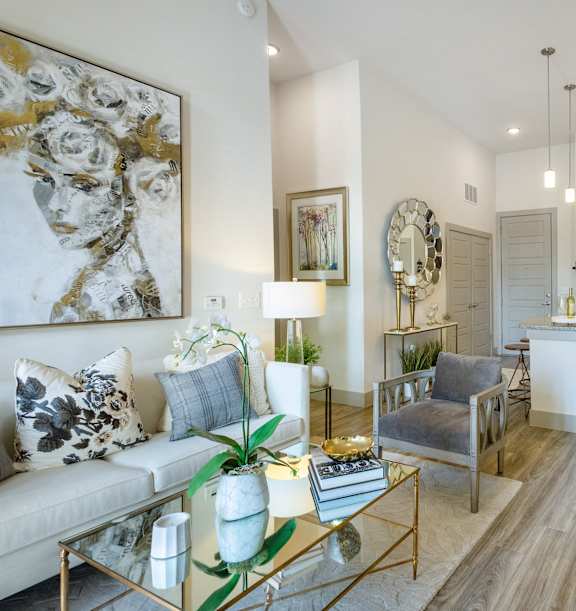 A modern living room with a white sofa and a glass coffee table.