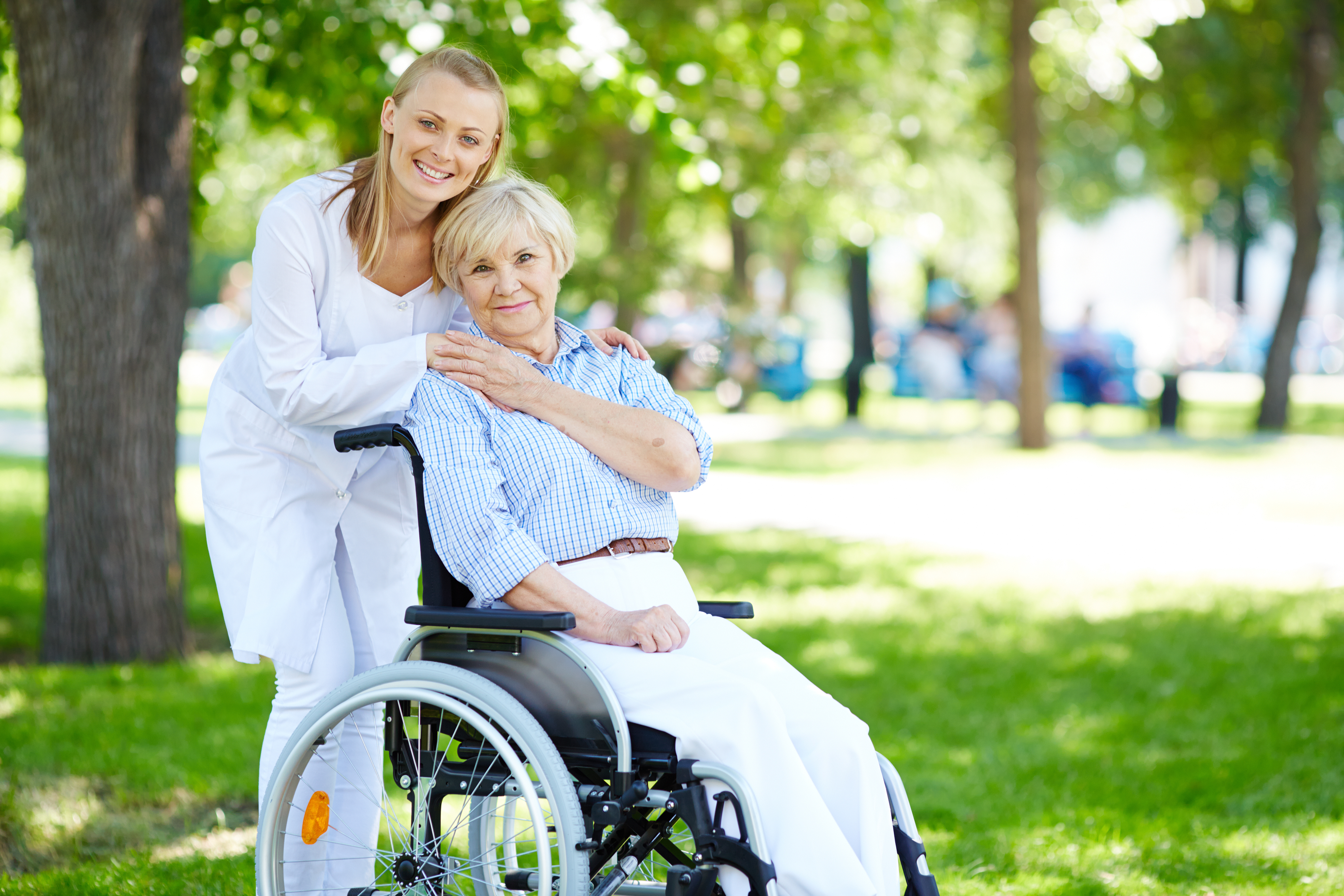 A caregiver smiling with a senior resident outdoors at The Berkeley