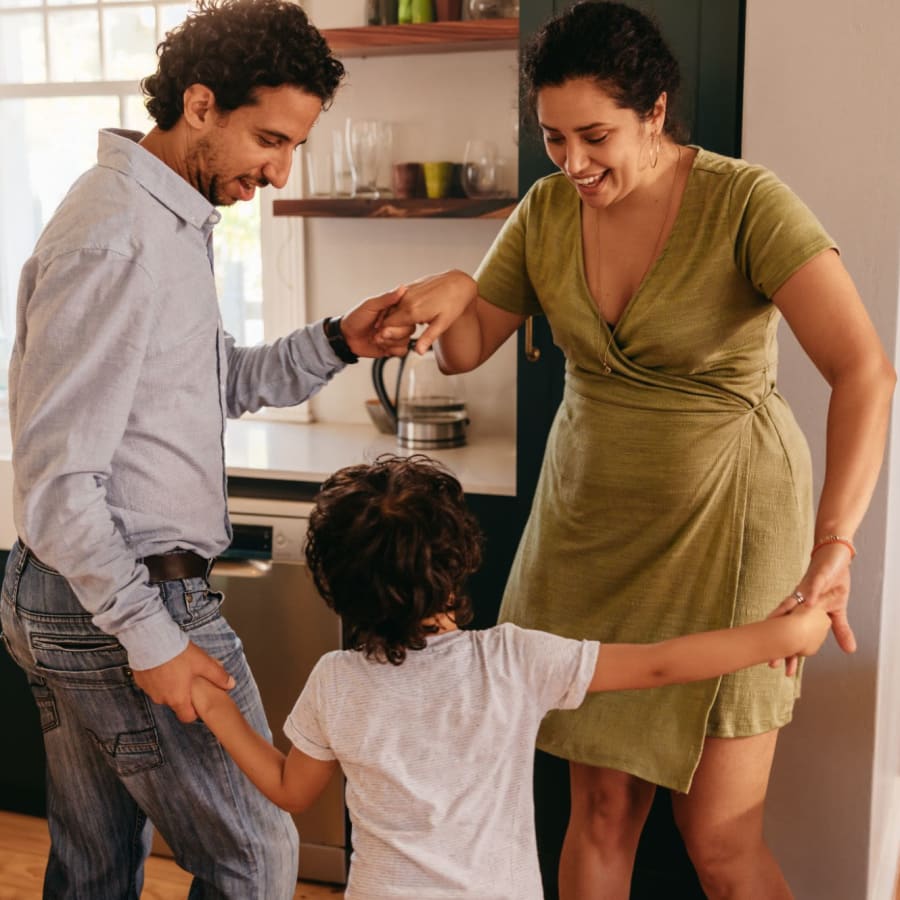 Residents dancing in their living room with their child at home at Baxter Street in Charlotte, North Carolina