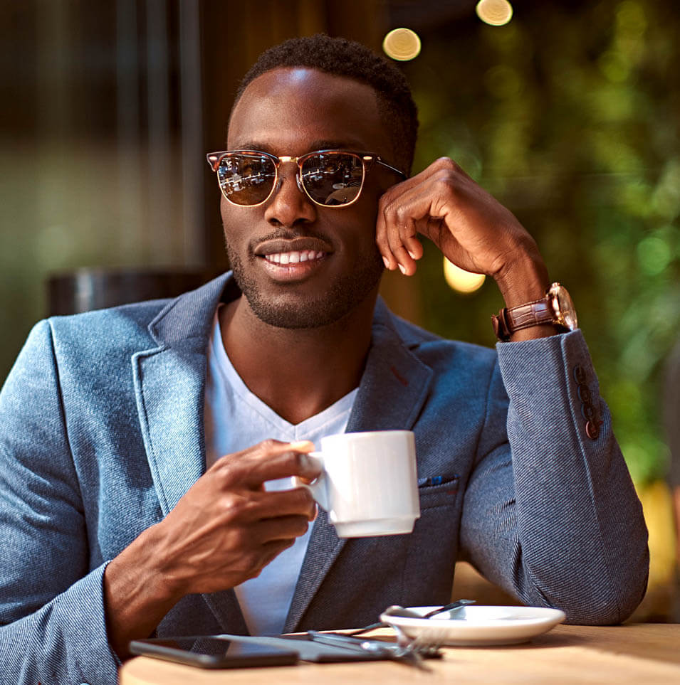 Man in sunglasses enjoying a cup of coffee.