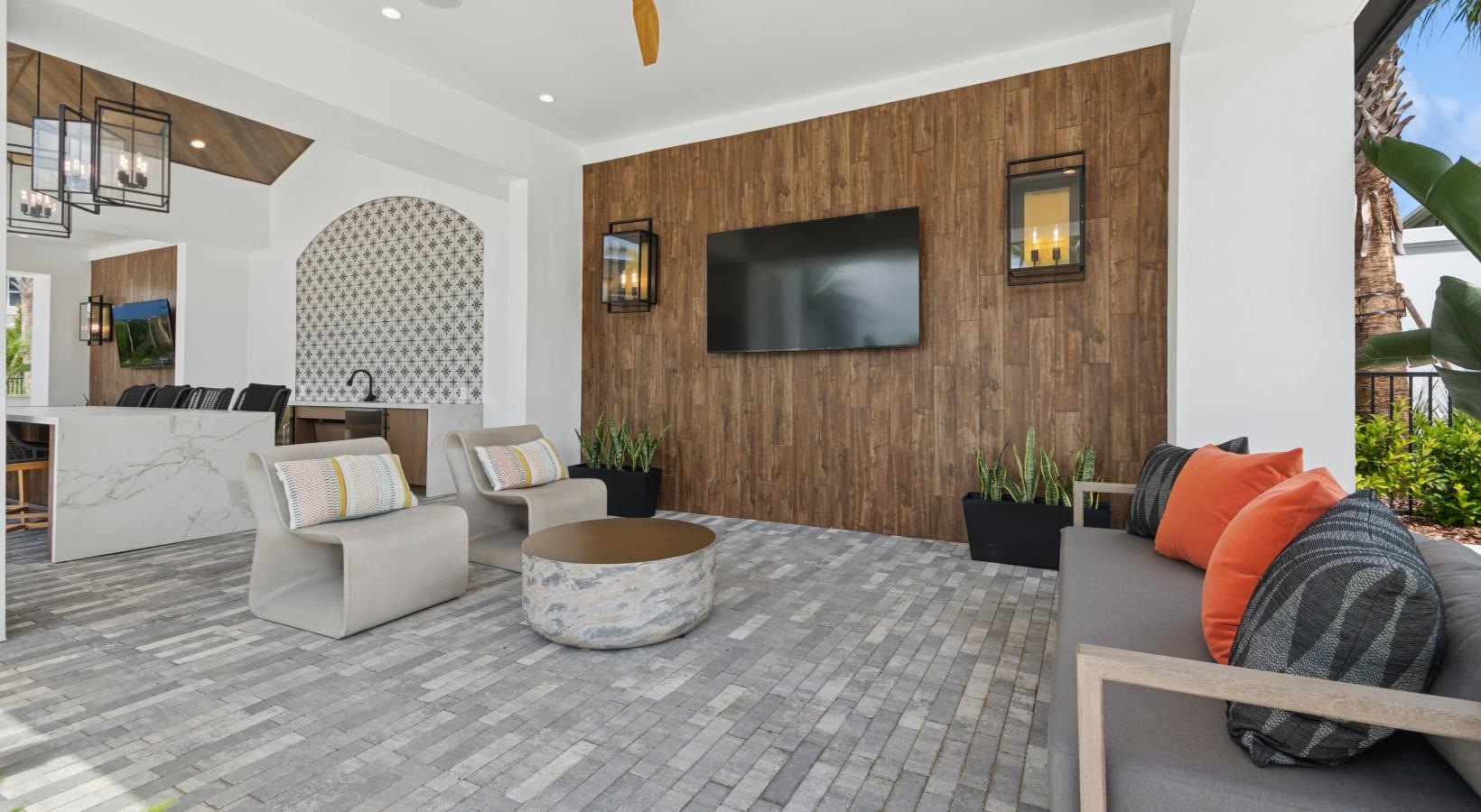 a living room with a large tv and a large stone wall
