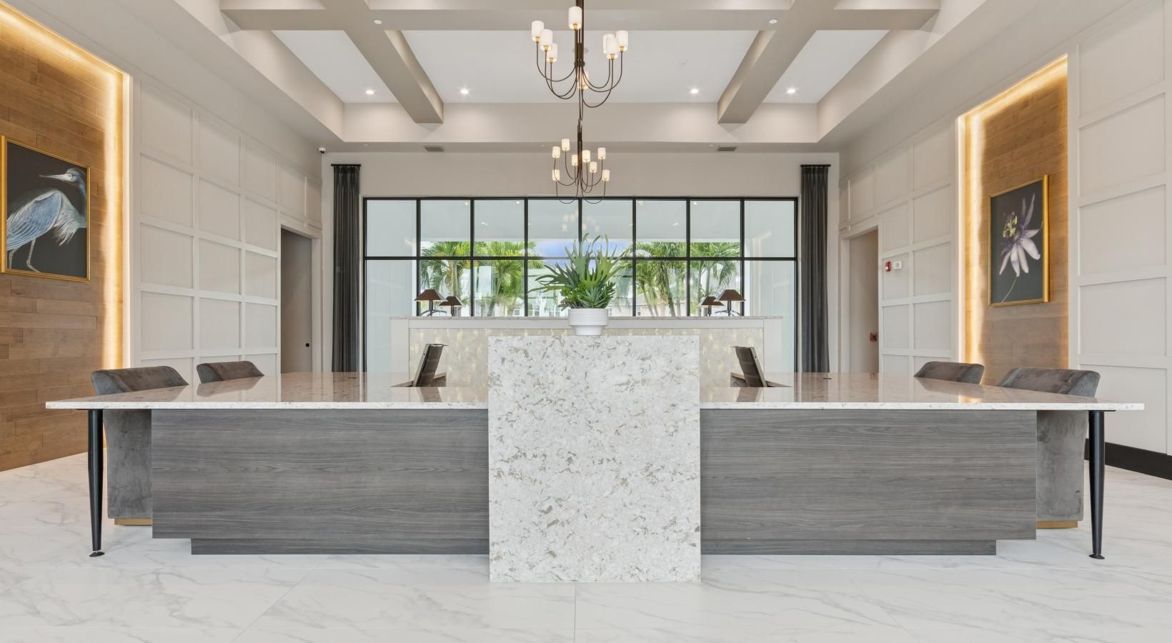 Reunion, FL, Luxury Apartments Near Champions Gate - Ascend Reunion Crossing - Lobby Area with a Large Table, Chairs, Chandeliers, Recessed Lighting, Wall Arts, and Large Windows.elier