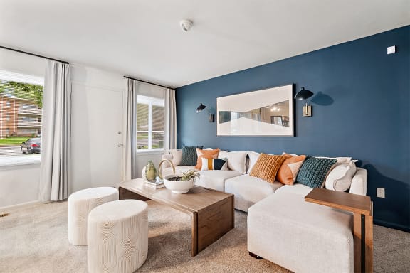 a living room with blue walls and a white couch at Falls Village Apartments, Baltimore, MD, 21209