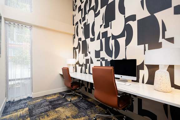 a room with two desks and two chairs and a window