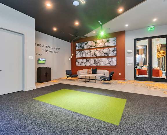 a living room with a large screen on the wall and a couch and chairs