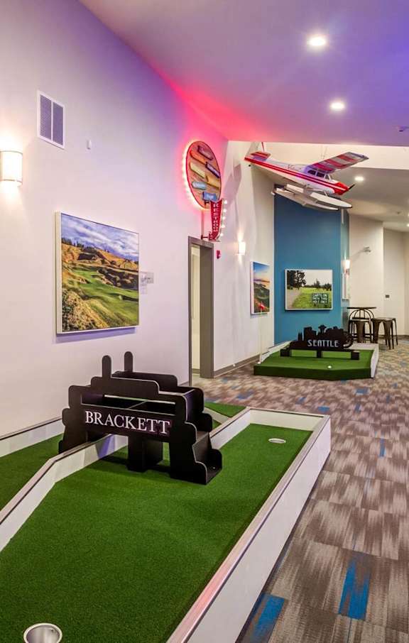 A pool table in a room with a blue wall and a picture of a pool table. at Brackett Apartments, Edmonds, WA, 98020