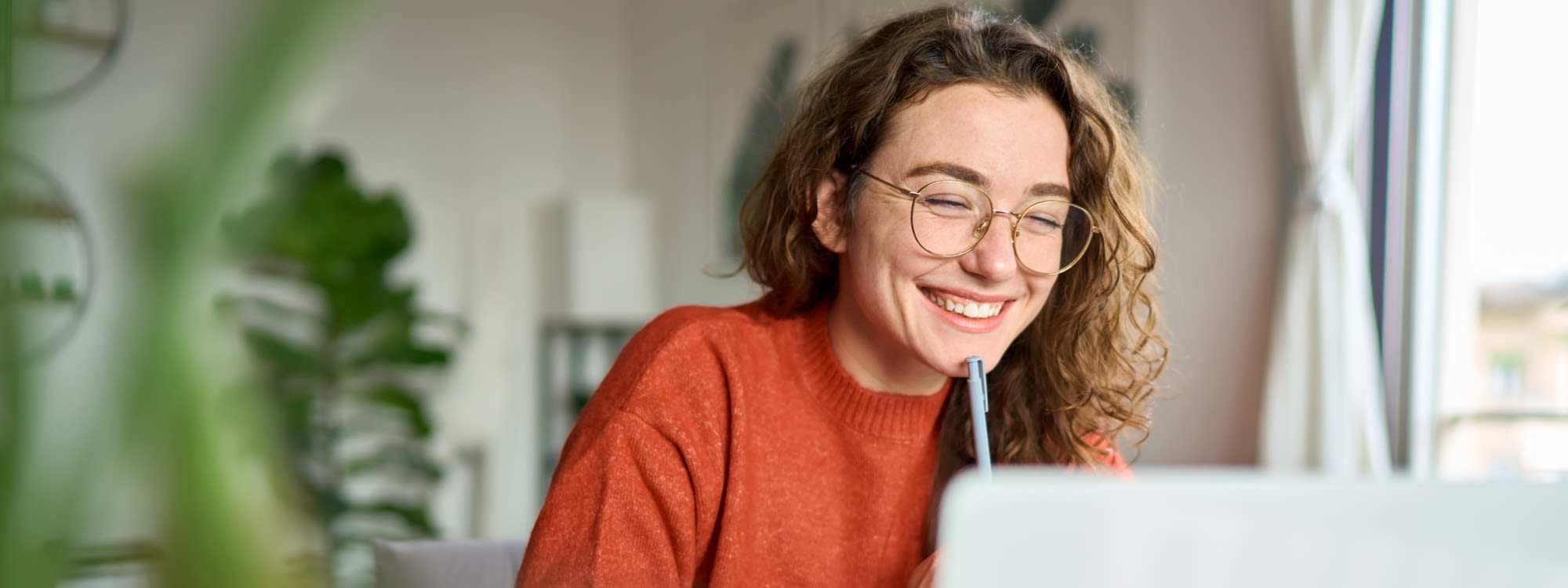 Resident in a living room with her laptop at Tucson, Arizona, student apartments at Malibu