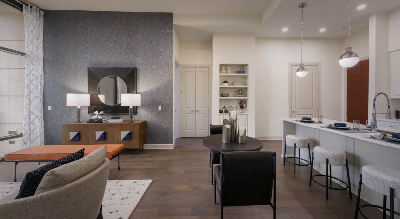 Furnished living space with view of living room and kitchen with stainless steel appliances and hanging globe lights