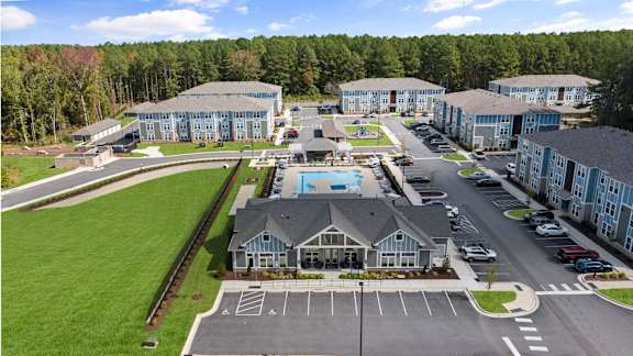 A large building complex with a pool and parking lot.