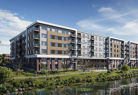A modern apartment building with a river in front.