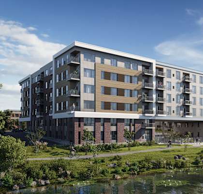 A modern apartment building with a river in front.
