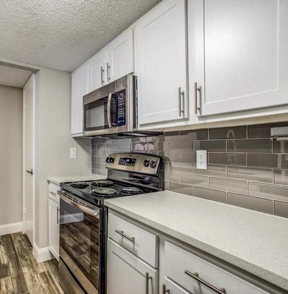 A kitchen with a stove top oven and microwave above it.