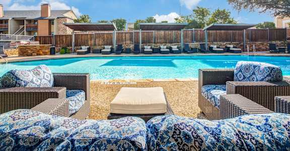 A pool surrounded by chairs with a blue and white blanket.