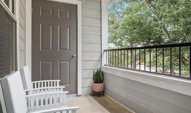 a white chair and a white table outside a house