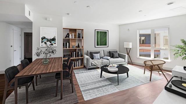 Living and dining room with modern furniture, artwork, and a bookshelf.