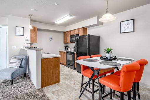 A kitchen with a table and chairs.