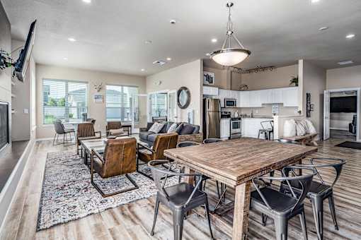 A modern open plan living and dining area with a wooden table and chairs.