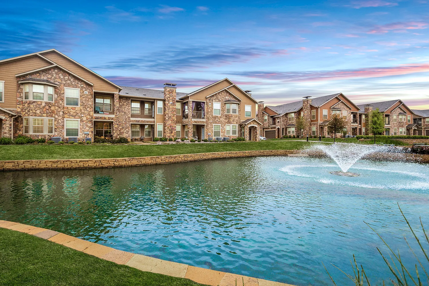 Exterior of the apartment buildings with an on-site pond and fountain