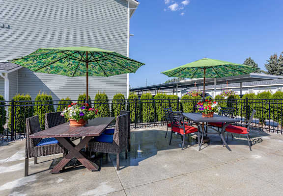 A patio with a table and chairs under green umbrellas.