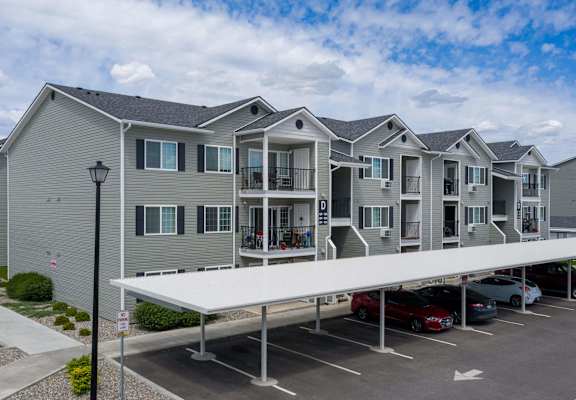 A row of houses with a parking lot in front.