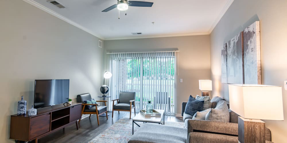A spacious living room with a fireplace and sliding door to the balcony at The Belvedere in North Chesterfield, Virginia