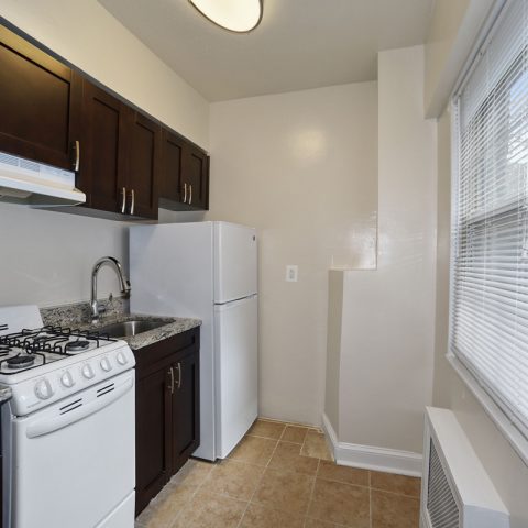 Contemporary hardware, espresso-stained Shaker cabinetry, and GE appliance package shown