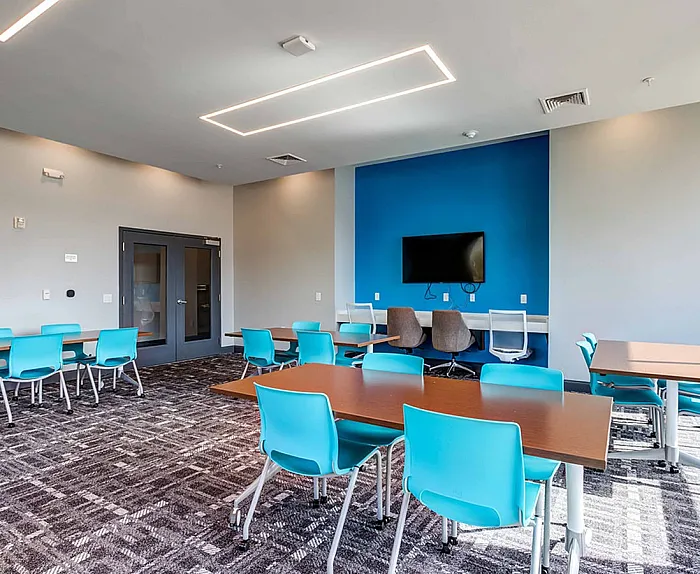 Co working space at College View Student Apartments in Starkville, MS, featuring desks, chairs, and carpeted flooring.