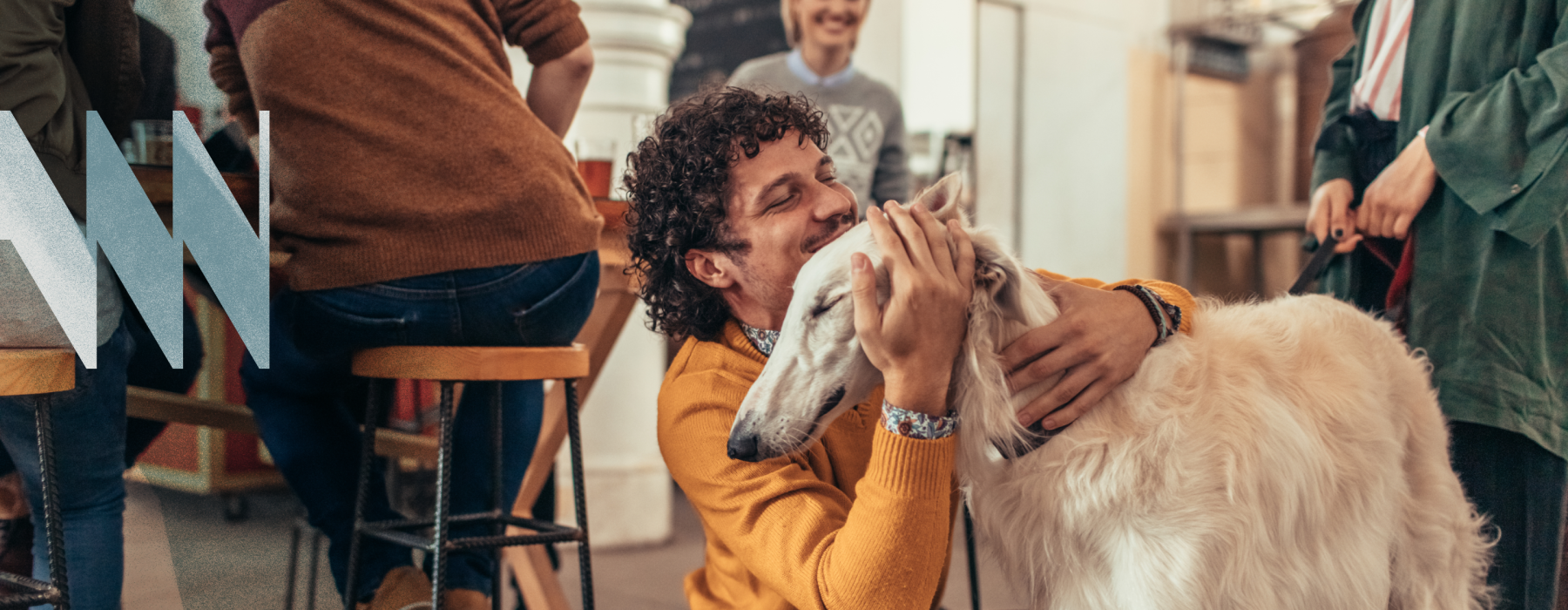 A man in a yellow sweater hugging a large white doc at Westerly House apartments in Nashville, TN.