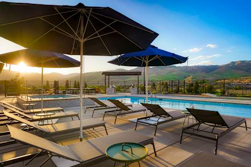 A sunny day at the pool with lounge chairs and umbrellas.